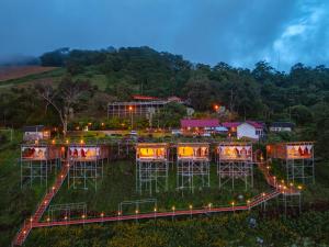 Ban Huai Khuหลงฮักเขาแคมป์ปิ้ง ภูชี้ฟ้า的草地上摆放着椅子和灯光的建筑