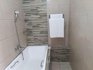 a bathroom with a bath tub and a towel at Long on Hill in Johannesburg +11 photos