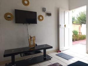a living room with a tv on the wall at Long on Hill in Johannesburg