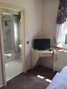 a bathroom with a tub and a television on a counter at Hotel Alte Posthalterei in Creuzburg