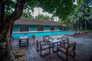 Un grupo de mesas y sillas junto a una piscina. en Laan Mai Fai Chang Resort, en Ban Nong Chaeng 18 fotos más
