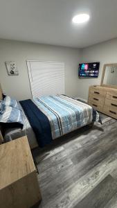 a bedroom with a bed and a flat screen tv at Modern Family Home -3BR -High Speed Wi-Fi Comfort in Sterling Heights