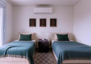 two beds sitting next to each other in a room at Juquehy - Duplex in prime area 1 block from the beach in Juquei +14 photos