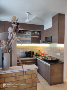 une cuisine avec des armoires brunes et un vase de fleurs dans l'établissement Ocean Breeze Retreat ModernVilla,Palavakkam, à Chennai