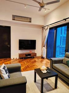 a living room with two couches and a flat screen tv at The Mews KLCC By Service Apartment in Kuala Lumpur