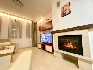 a living room with a fireplace and a tv at GS SKI Apartment - The Grand Monastery Pamporovo in Pamporovo