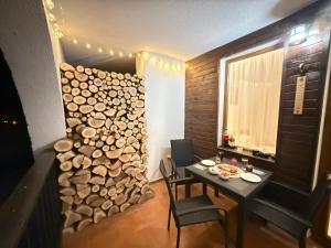 a dining room with a table and a pile of wood at GS SKI Apartment - The Grand Monastery Pamporovo in Pamporovo