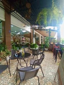an outdoor patio with tables and chairs and plants at Memory Hotel Vientiane in Vientiane