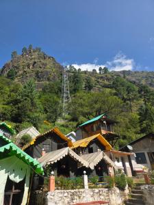 a building with a mountain in the background at Jalpa Camp Kasol in Kulu