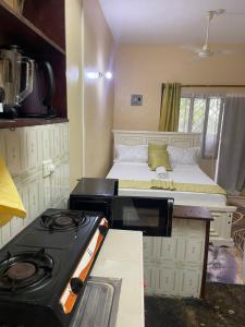 a kitchen with a stove and a bed in a room at Cate Studio Malindi in Malindi