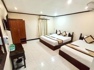 a hotel room with two beds and a television at Memory Hotel Vientiane in Vientiane