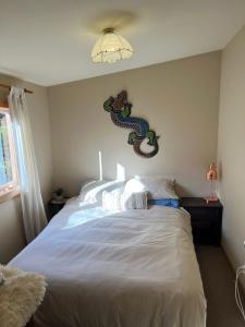 a bedroom with a bed with a dragon on the wall at Quaint Country Cottage 