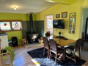 a living room with a wooden table and a fireplace at Quaint Country Cottage in Pokororo