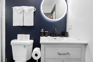 a white bathroom with a sink and a mirror at North Chi retreatNavySaunaTiki BarGames in North Chicago +29 photos