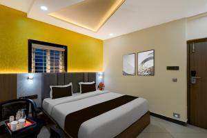 um quarto com uma cama grande em um quarto em Super Townhouse Oak Premier Raidurg Biodiversity Park em Madhapur