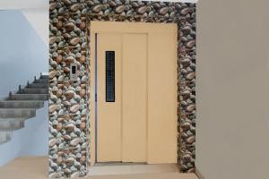 Maula AliにあるSuper Townhouse Cherlapally Bus Terminal Formerly Hotel Chakripuramの石壁の部屋への扉