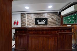 a wooden bar with a sign on top of it at Hotel O Alappuzha Near General Hospital Junction in Alleppey