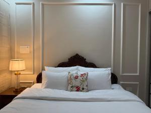 a bed with white sheets and pillows in a bedroom at EvaraNiketan in Bengaluru