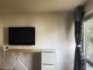 a living room with a television on a wall at Octoberfest room in Unterschleißheim