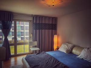 a bedroom with a bed and a large window at Octoberfest room in Unterschleißheim