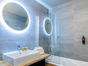 a bathroom with a sink and a shower with a mirror at Ibis Styles Crolles Grenoble A41 in Crolles