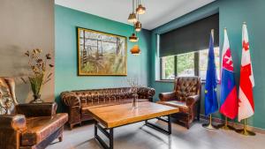 a living room with leather furniture and flags at Hotel Gino Wellness Mtskheta in Mtskheta