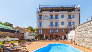 a hotel with a swimming pool in front of a building at Hotel Gino Wellness Mtskheta in Mtskheta