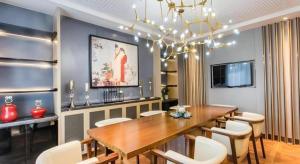 a dining room with a wooden table and white chairs at Magnotel Hotel Suzhou Shiquan Street Wangshiyuan in Suzhou