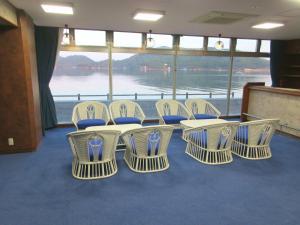 a table and chairs in a room with a view at 森口屋アートスクエア in Shodoshima