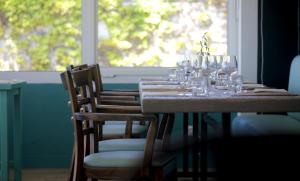 a table with wine glasses on it with a window at Dormir sur la Plage in Marennes