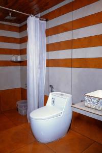 a bathroom with a toilet and a shower curtain at Wild Stories Resort, Munnar in Anachal +55 photos