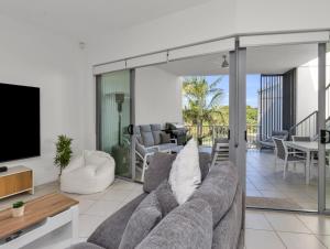 a living room with a couch and a tv at Drift North Beachfront Apartments - Private Apartments in Kingscliff
