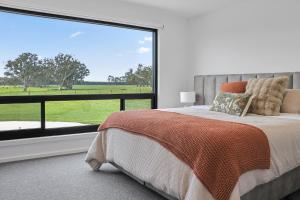 a bedroom with a bed and a large window at Warrawindi Escapes in Penola