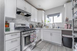 a kitchen with white cabinets and a stove top oven at 近ONT机场 Chaffey Claremont学院 Ontario Outlets 3Br2BA in Rancho Cucamonga