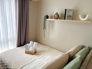 a bedroom with a bed with a basket of towels at Kasara Urban Residences in Pasig City - Solmera Cove in Manila +15 photos