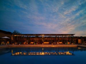 a lit up swimming pool with a pavilion at night at The Asbury Hotel in Asbury Park