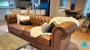 a brown leather couch sitting in a living room at Lake Breeze - lakeside, bushland escape, with plunge pool in Cams Wharf