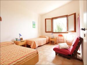 1 dormitorio con 2 camas, silla y ventana en Villa Zahara, en Ribera