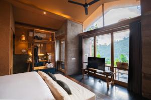 a bedroom with a bed and a large window at Amora Ubud Boutique Villas in Ubud