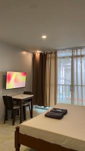1 dormitorio con cama, escritorio y monitor en Isla Haus Boracay, en Boracay