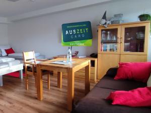 a living room with a table and a sign on the wall at Ferienwohnung Trifts l Wallbox l Parkplatz l AusZeit Card in Wangen im Allgäu +43 photos