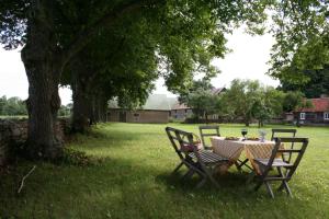 a table and chairs in the grass under a tree at Greby Bed & Breakfast in Räpplinge