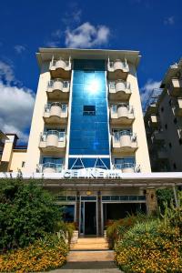 a building with the sun shining on the front of it at Kleopatra Celine Hotel in Alanya