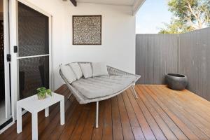a porch with a bench on a wooden deck at Drift & Dwell - Minutes to Labrador Beach & Dining in Gold Coast