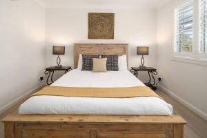a bedroom with a large bed with two lamps at Drift & Dwell - Minutes to Labrador Beach & Dining in Gold Coast