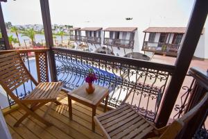 a balcony with two chairs and a vase of flowers at Costa Bitezhan Hotel - All Inclusive in Bitez
