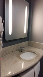 eine Badezimmertheke mit einem Waschbecken und einem Spiegel in der Unterkunft ibis Juiz de Fora in Juiz de Fora