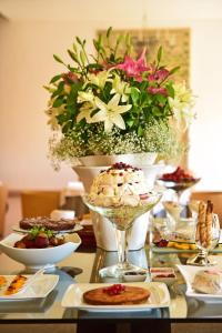 a table with plates of food and a vase with flowers at Pousada Mosteiro do Crato in Crato