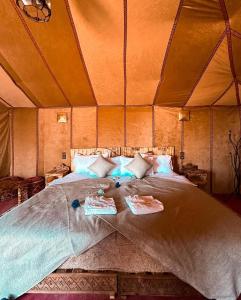 a bedroom with a large bed in a tent at merzouga camping in Merzouga