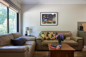 a living room with two couches and a table at Goldfield Holiday Units in Bright